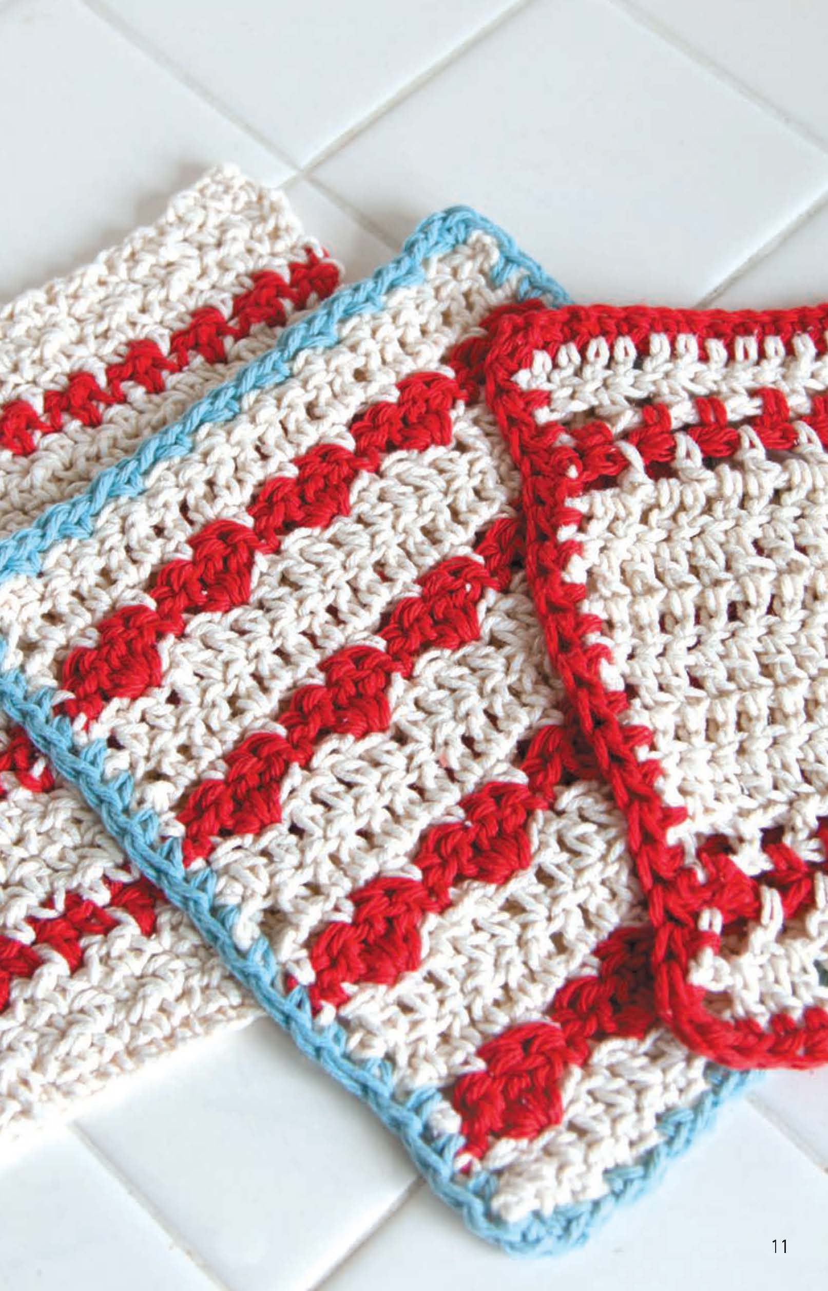 Leisure Arts Dishcloths—two crocheted cotton pieces in cream and red diagonal stripes with a light blue border—rest on white tile. Ideal for beginners seeking new crochet patterns or easy projects.