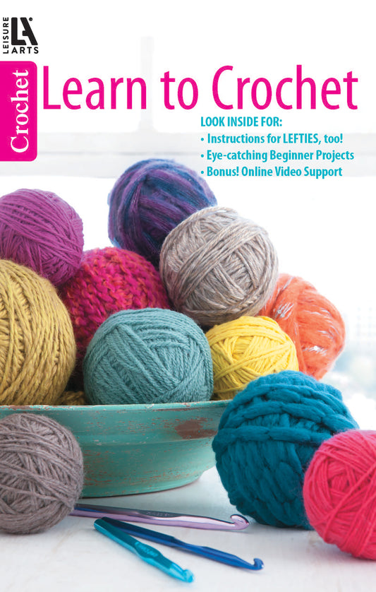 A vibrant bowl of yarn balls with crochet hooks. Text: Learn to Crochet—Instructions for Lefties, Too! Eye-Catching Beginner Projects; Bonus Online Video Support. By Leisure Arts.