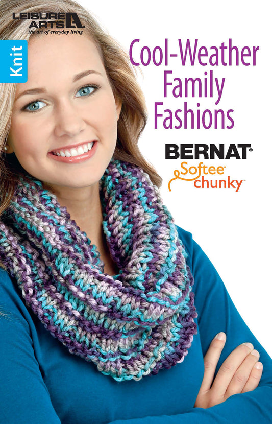 A smiling woman in a teal top models a thick, multicolored knit scarf. Text reads "Cool-Weather Family Fashions" by Leisure Arts. The image promotes a knitting patterns booklet for super bulky yarn.