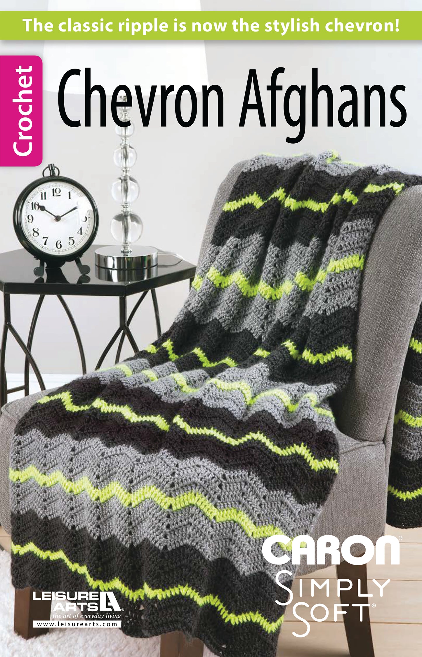 A gray, black, and green chevron crochet afghan drapes over a gray chair. Made with Caron Simply Soft yarn. Text reads "Chevron Afghans Digital Download by Leisure Arts." Perfect for cozy throws.
