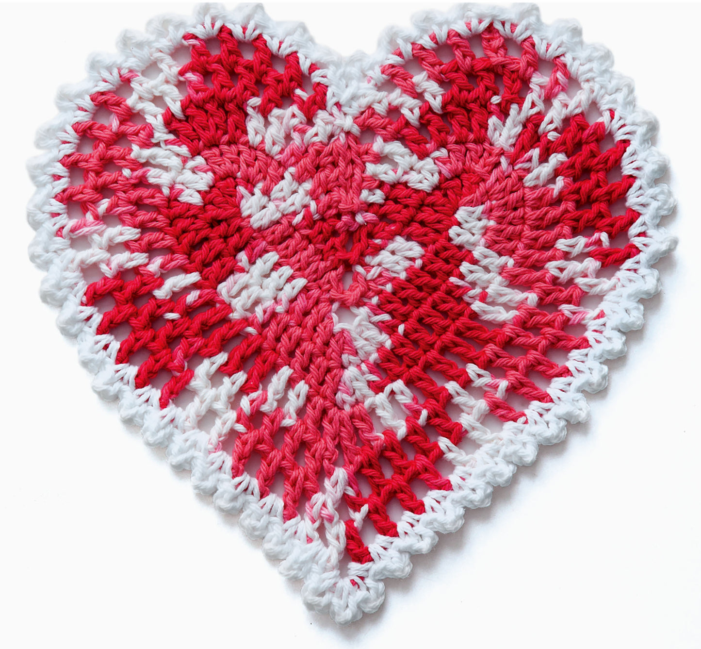 A heart-shaped crochet dishcloth in red, white, and pink yarn with a scalloped white border and handmade look—ideal for seasonal projects and beginners. Find this design in Leisure Arts’ "A Dishcloth A Month" digital download.