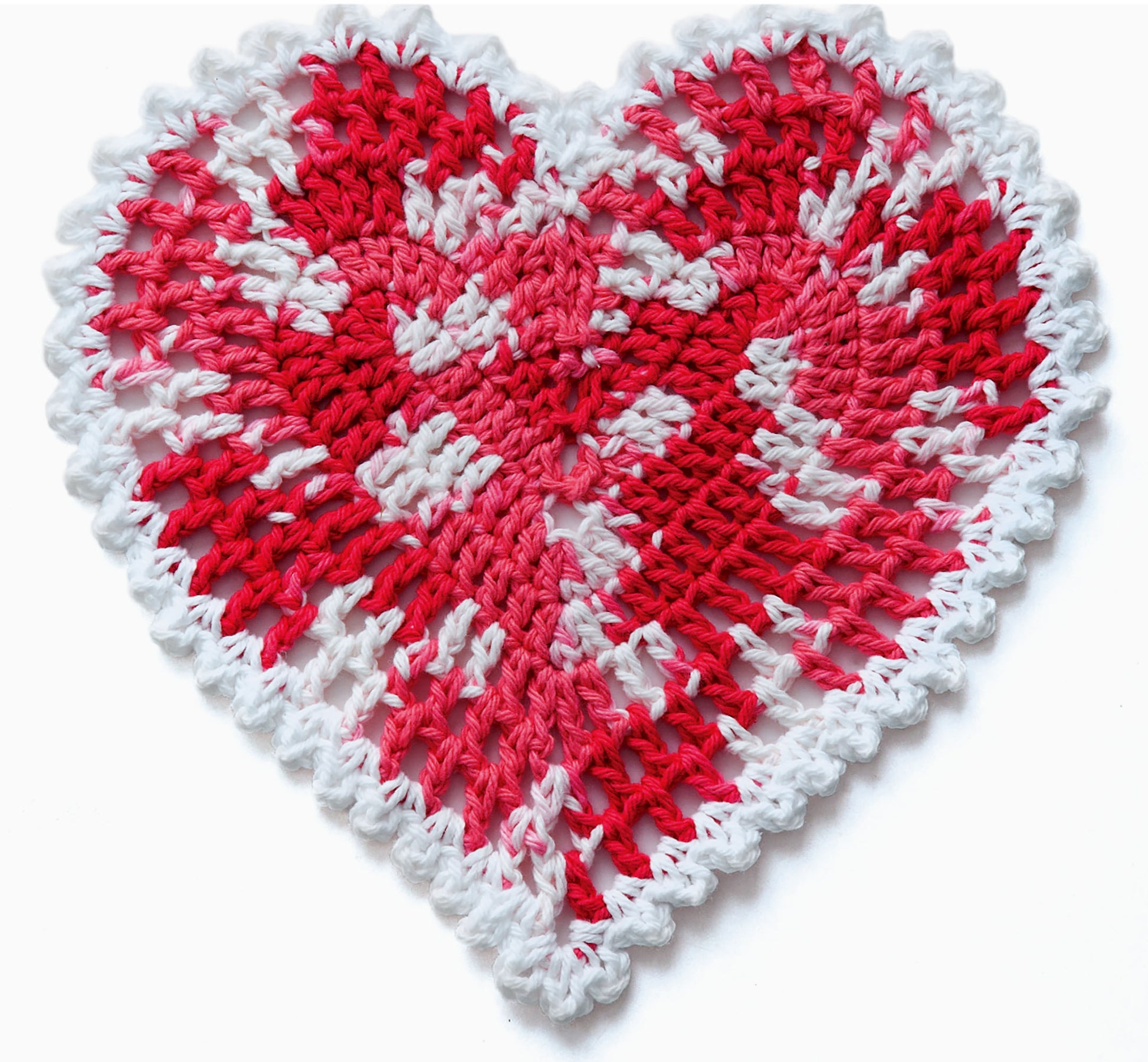 A heart-shaped crochet dishcloth in red, white, and pink yarn with a scalloped white border and handmade look—ideal for seasonal projects and beginners. Find this design in Leisure Arts’ "A Dishcloth A Month" digital download.