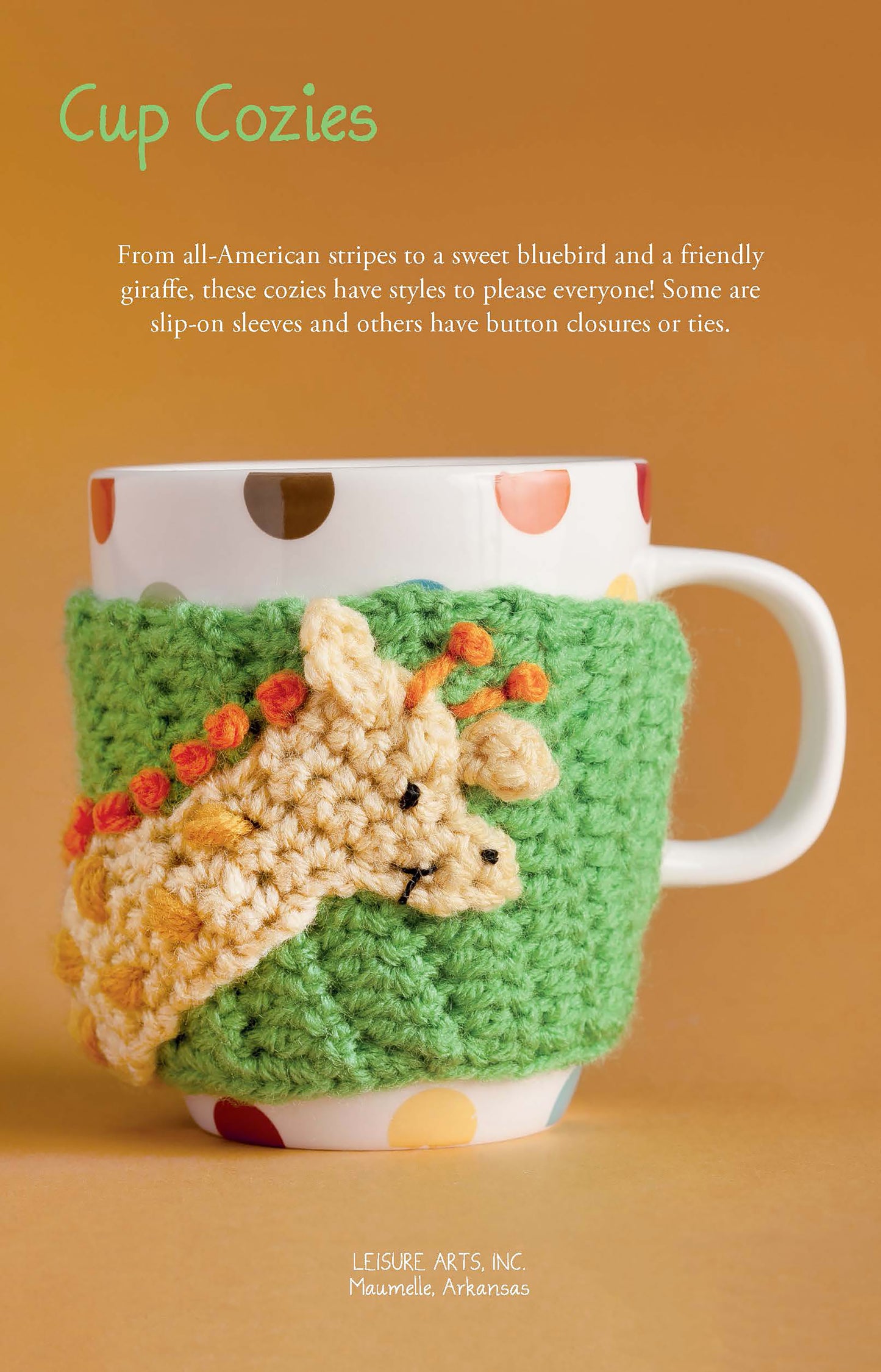 A white mug in a green crocheted cozy with a cute giraffe design spotlights Leisure Arts’ Cup Cozies—12 Designs, offering charming animal crochet patterns and cheerful inspiration for beginner crafters.