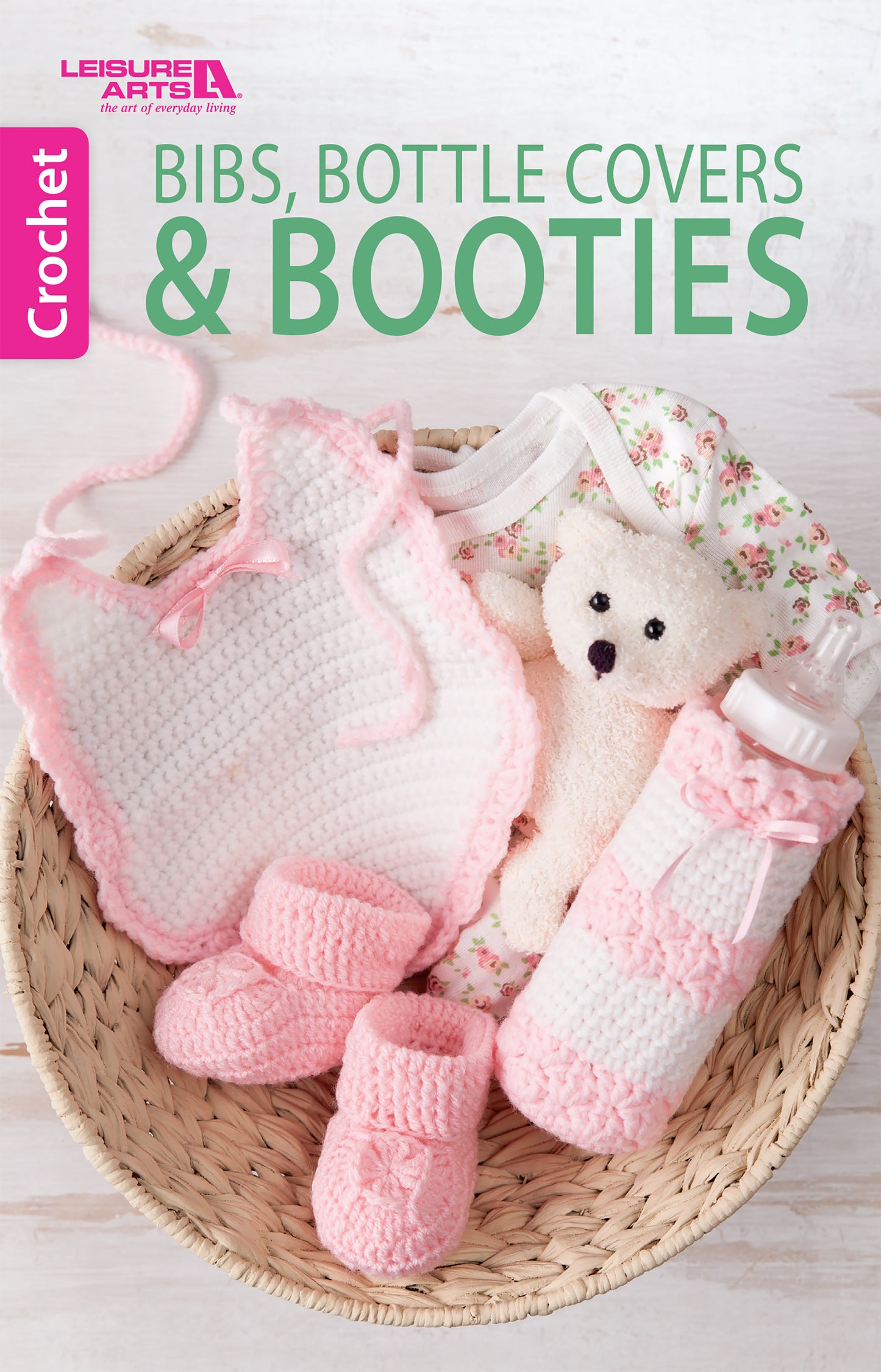 A basket features Leisure Arts' Bibs, Bottle Covers & Booties—a set with pink crocheted booties, a bib, bottle covers, and more for baby. The text reads: Bibs, Bottle Covers & Booties by Leisure Arts.