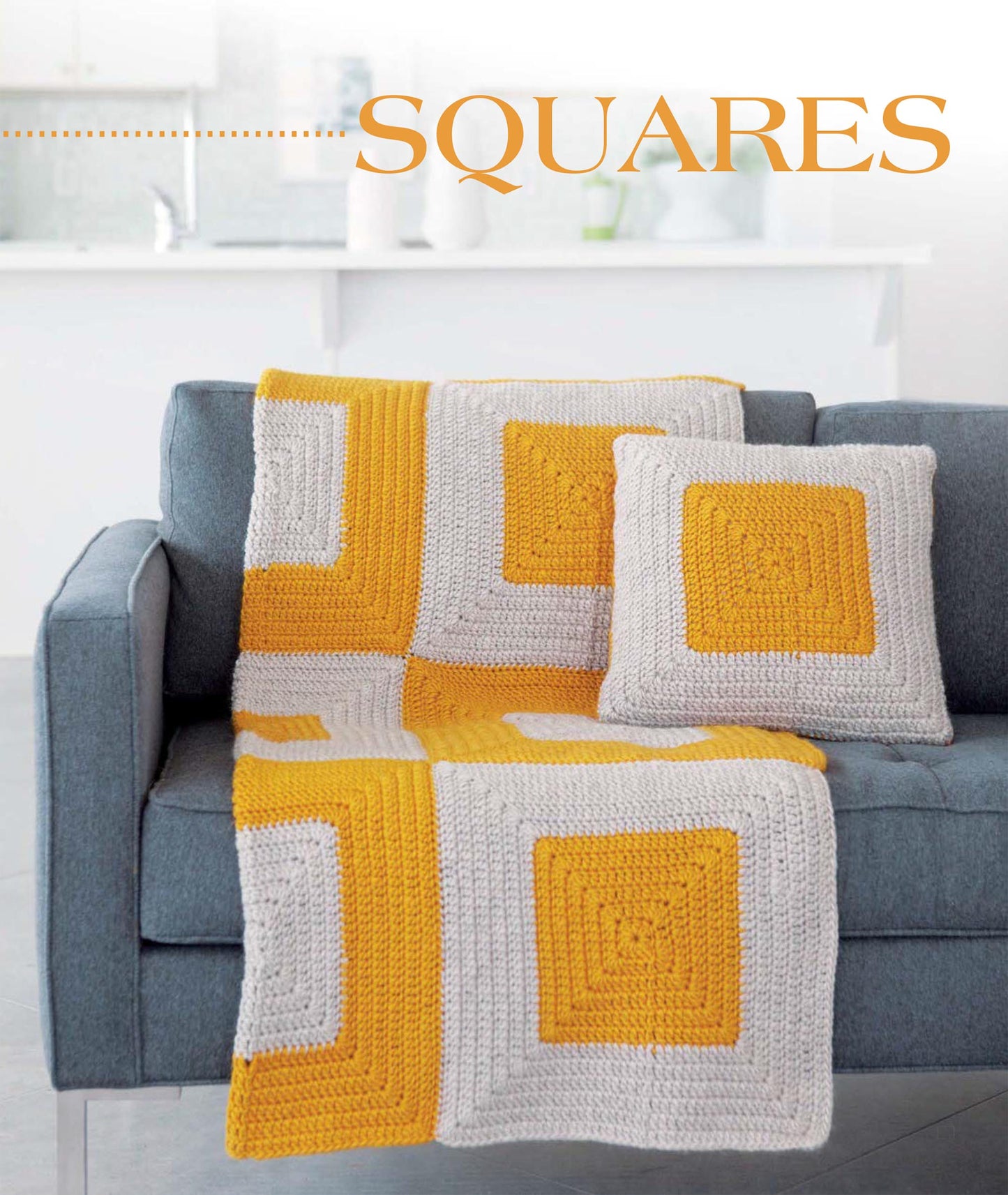 A bright, minimalist living room showcases the Leisure Arts Geometric Pillows & Afghans set—a modern blue sofa with a crocheted blanket and matching pillow in bold yellow and gray squares. "SQUARES" appears at the top in orange text.