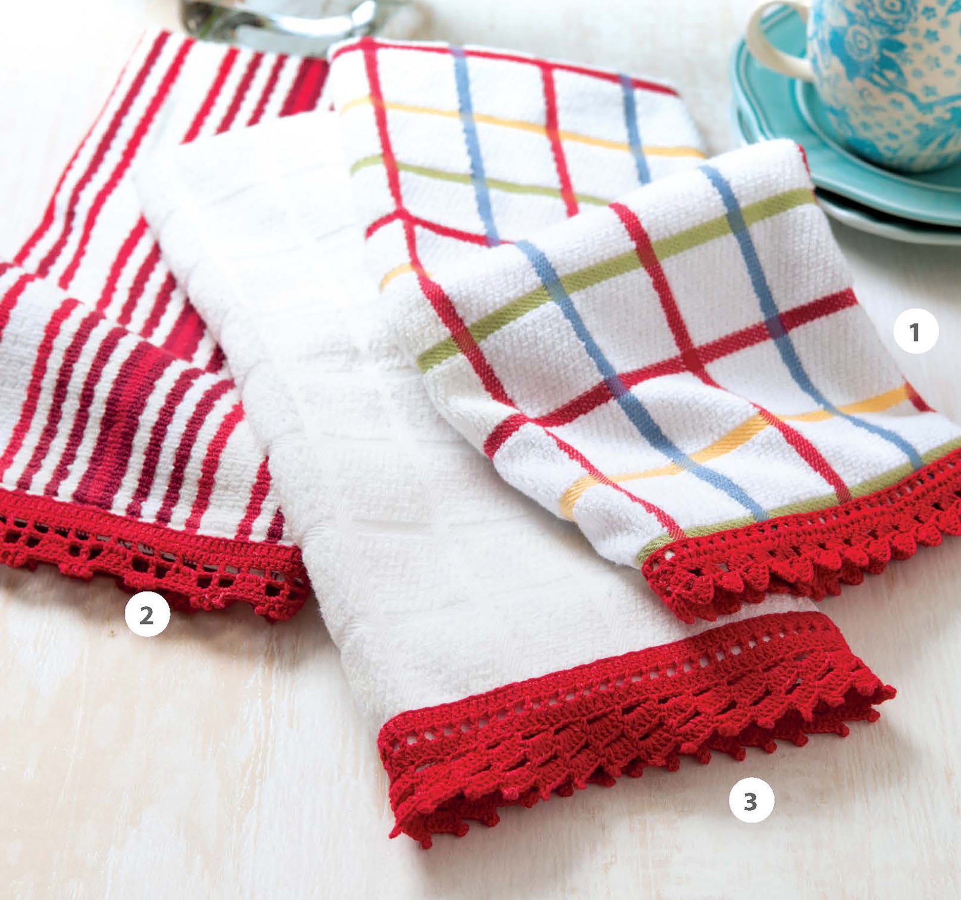 Leisure Arts' Quick Thread Projects Digital Download features kitchen towels with red crochet lace edging—multicolor plaid, red-striped, and plain white—styled near a turquoise teacup, ideal for beginner crocheters or home decor.