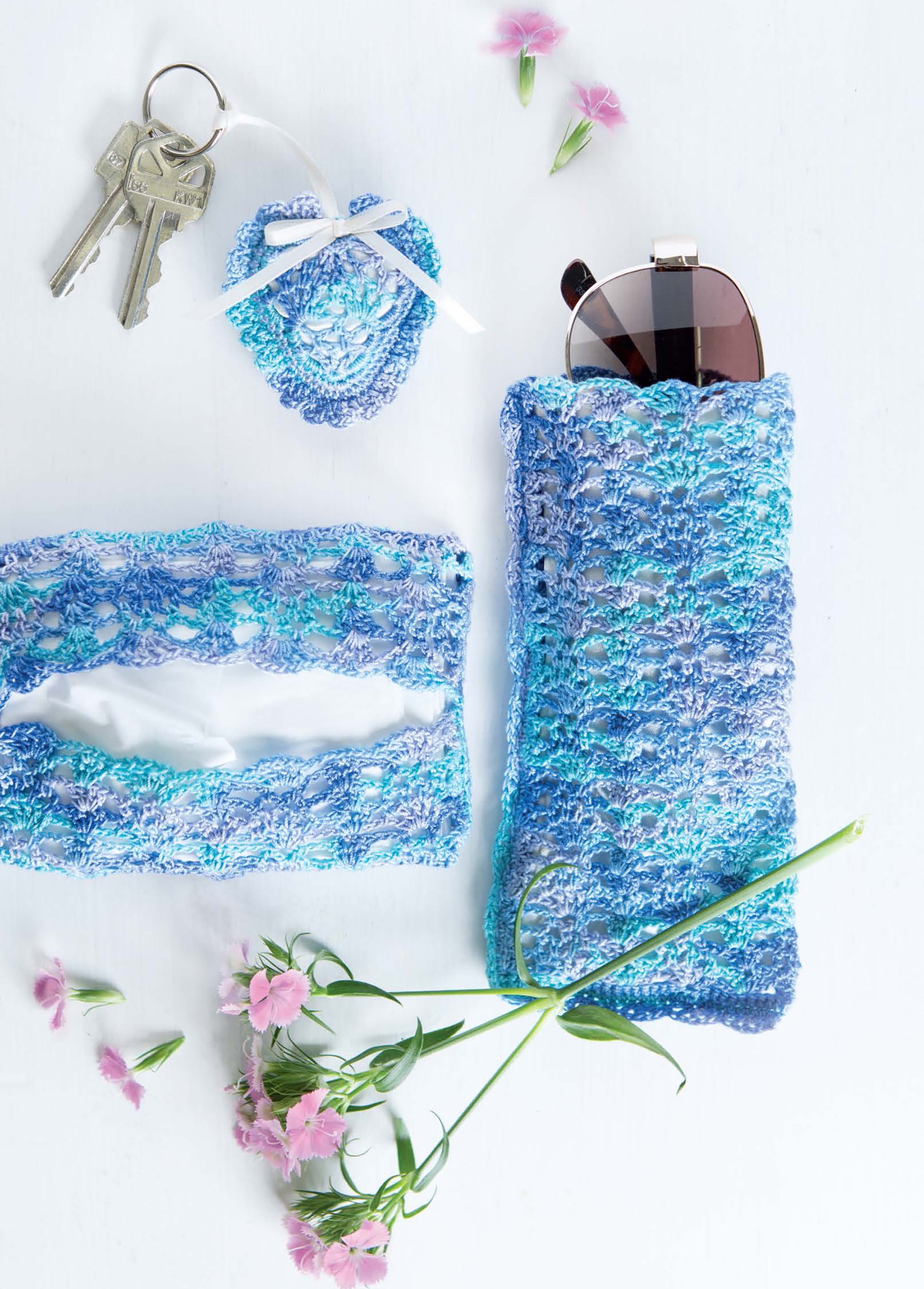 Quick Thread Projects Digital Download by Leisure Arts features blue and purple beginner crochet accessories—a sunglasses case, tissue holder, heart keychain—displayed on a white surface with sunglasses, keys, and pink flowers.