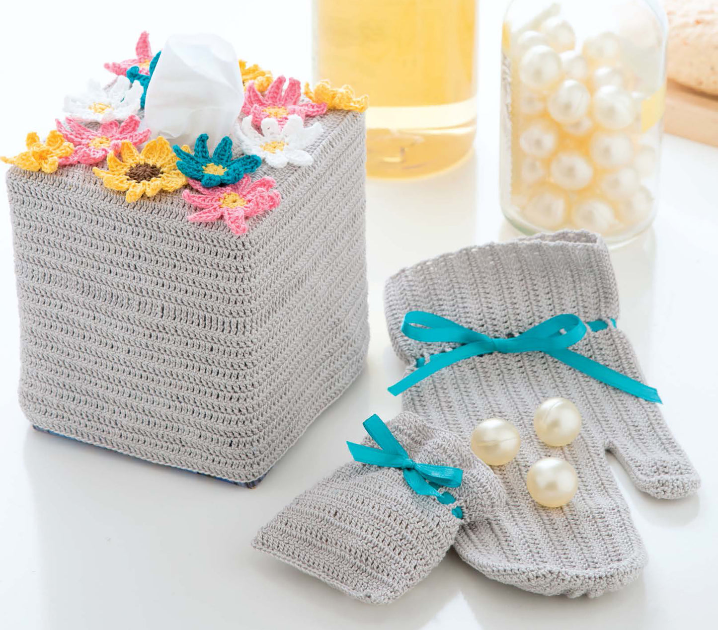 The Quick Thread Projects Digital Download by Leisure Arts features a gray crocheted tissue box cover with colorful flowers and matching gray mittens with blue ribbon—perfect for adding charm to your home or inspiring beginner crochet projects.