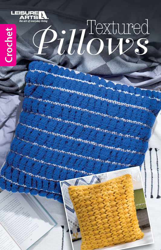 The Leisure Arts Textured Pillows Crochet book cover shows a blue striped crocheted pillow on a bed, plus an inset gold textured pillow—ideal for beginners and fans of textured crochet designs.