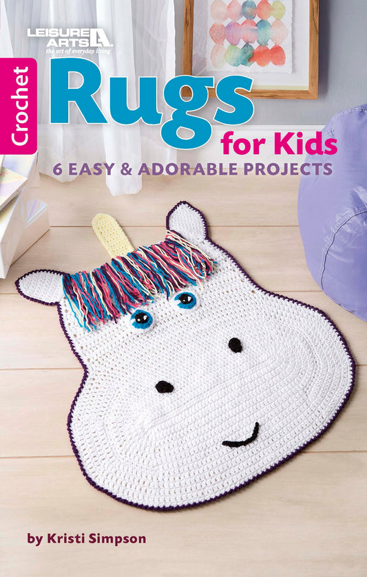 The cover of Leisure Arts' "Crochet Rugs for Kids" shows a crocheted white unicorn rug with a colorful mane and blue eyes on wood floor. The book features 6 easy, adorable beginner projects ideal for playroom decor.