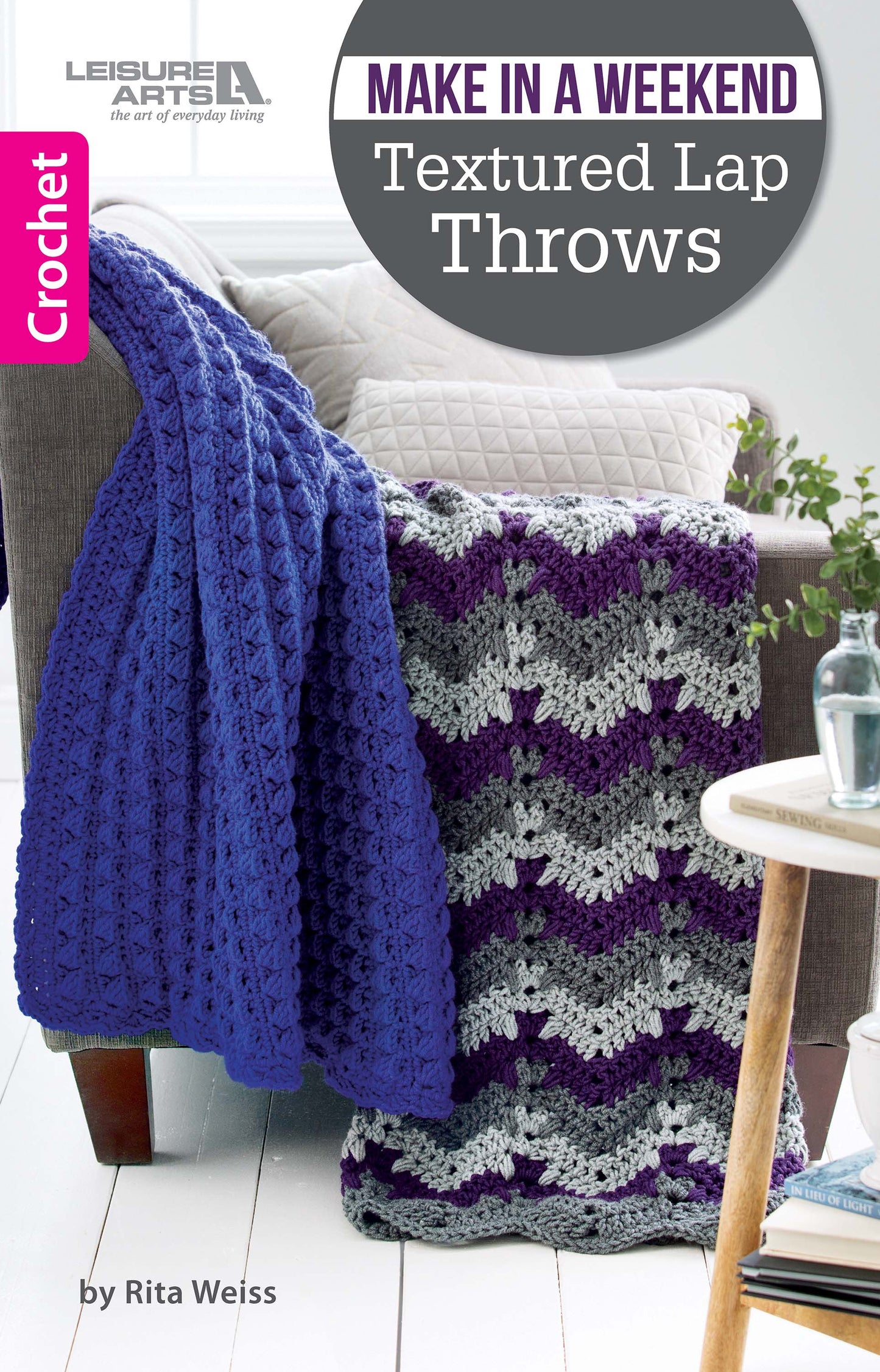 A chair with two blue and purple-gray crocheted lap throws draped over it. The cover shows "Make in a Weekend Textured Lap Throws Digital Download" by Leisure Arts, featuring beginner-friendly crochet patterns.