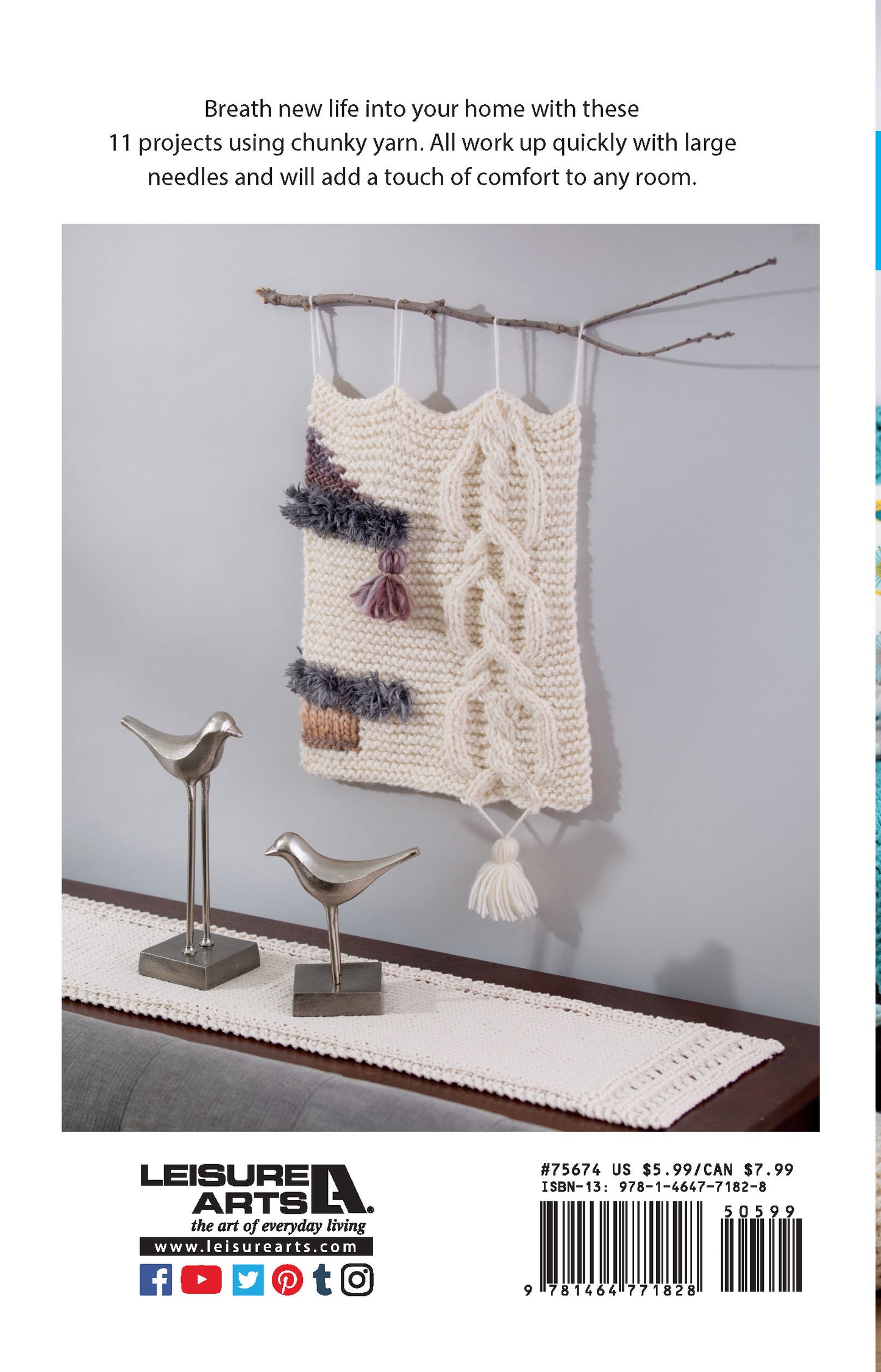 Display the Leisure Arts Chunky Home Decor Digital Download as a striking yarn wall hanging with tassels and texture, showcased on a wooden dowel above a table accented by silver bird sculptures and a white lace runner for elevated home style.