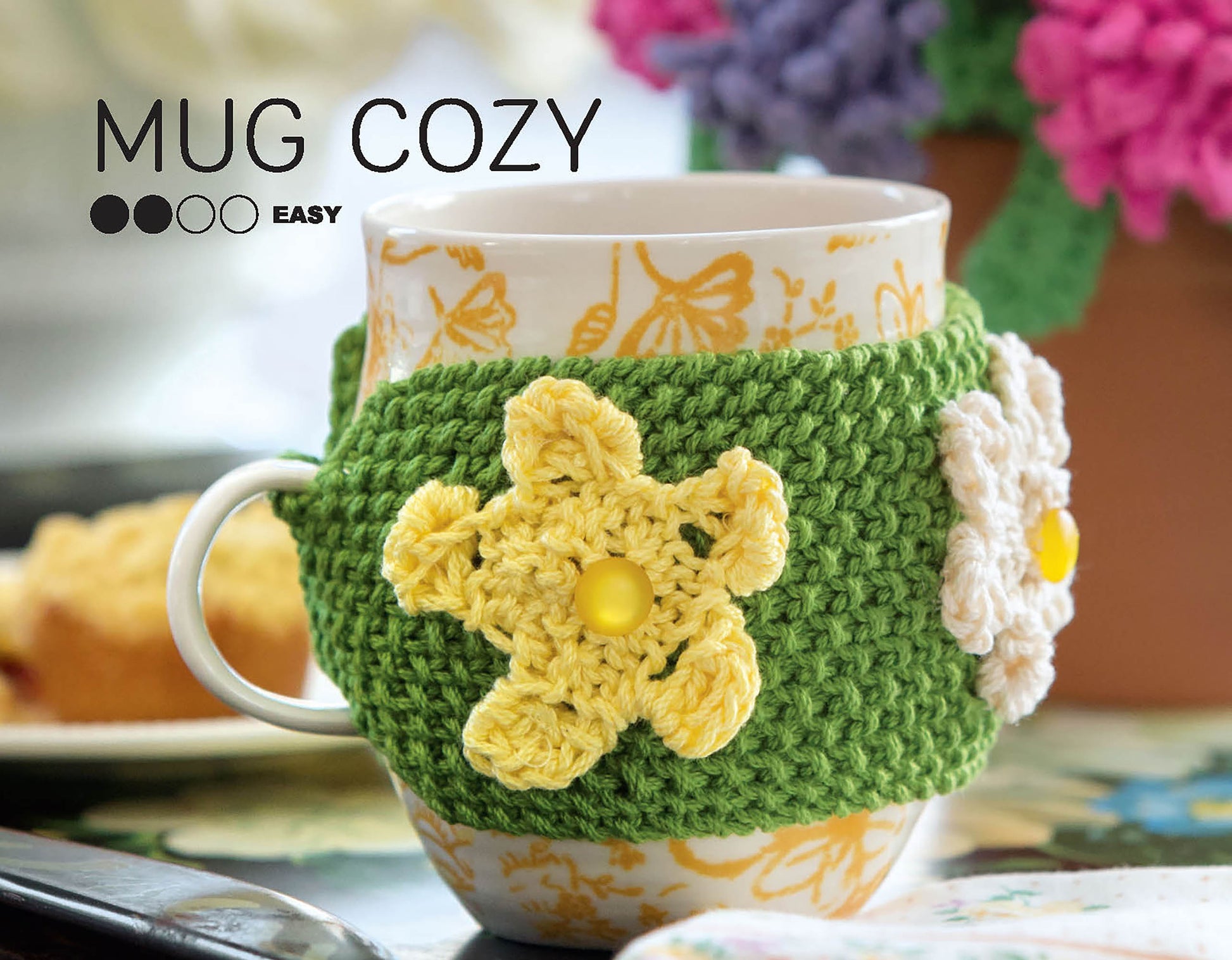 The “Stitch A Garden—18 Designs Charted for Beading and Cross Stitch” book by Leisure Arts offers vibrant floral patterns, perfect for inspiring colorful yarn crafts. The cover features the text “MUG COZY” and “EASY” in the top left corner.