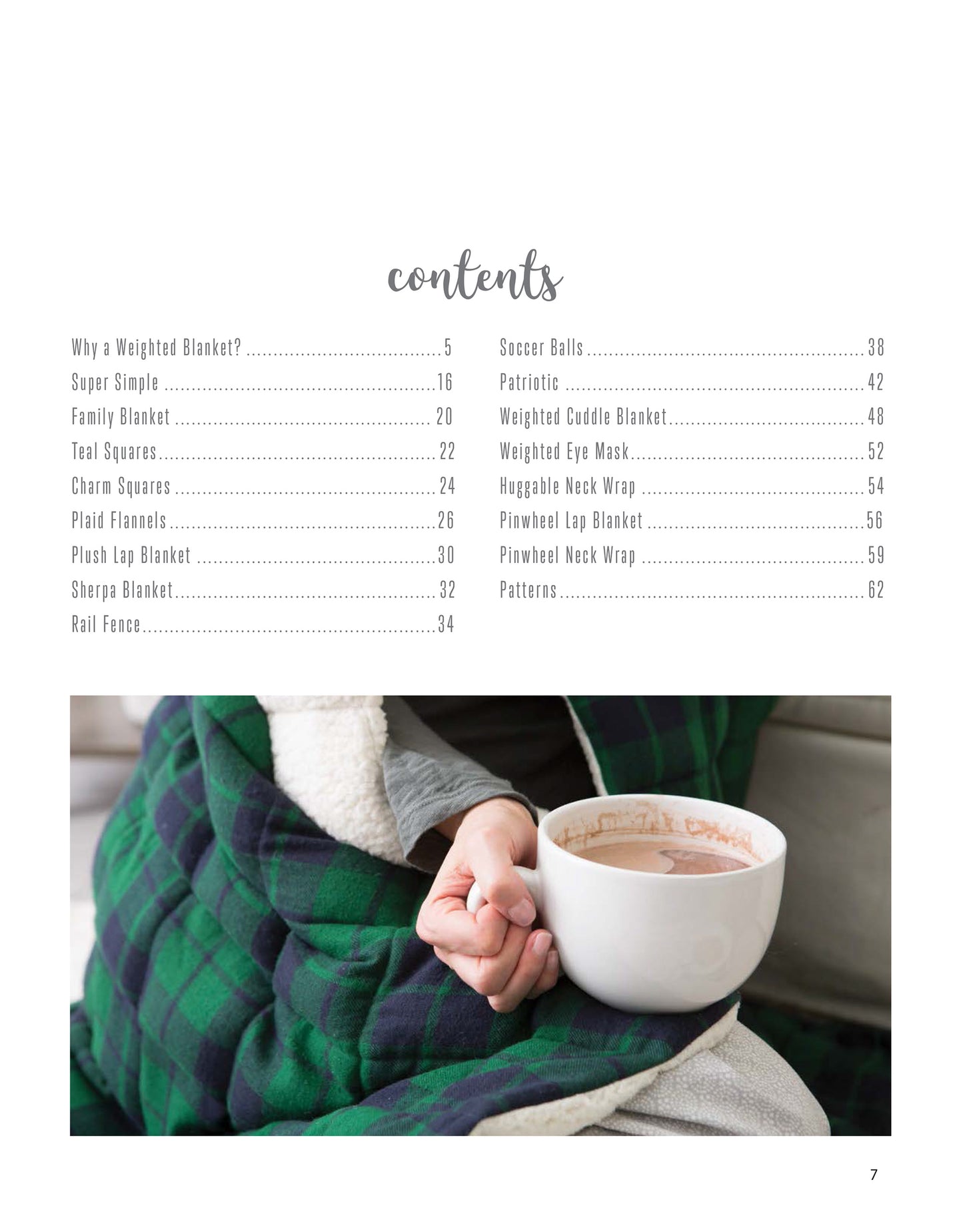 A person snuggles up in a Leisure Arts Cozy Weighted Blanket, green and navy checkered, sipping hot chocolate with marshmallows—a picture of warmth and relaxation.
