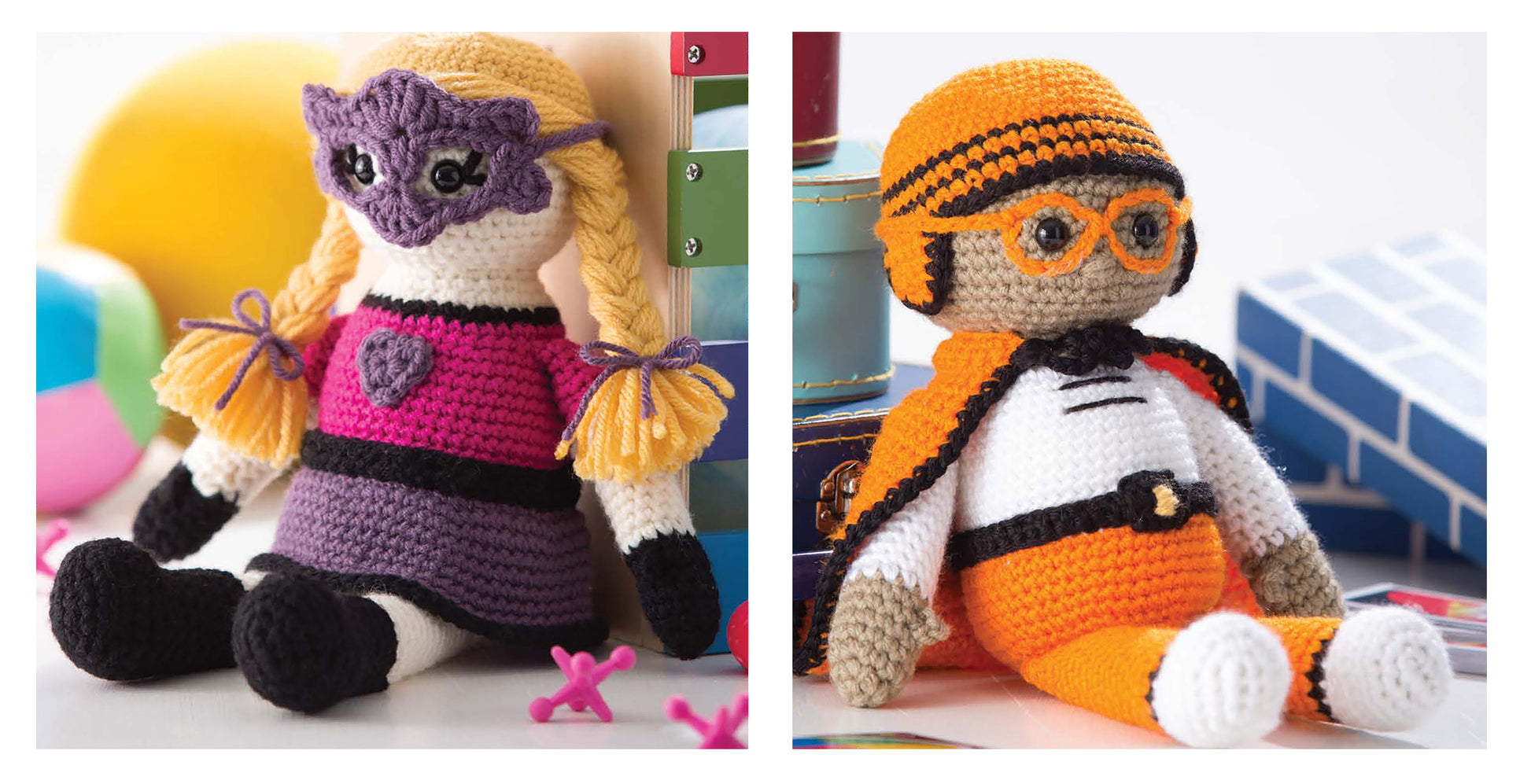 Two amigurumi crochet dolls from "Amigurumi An Adorable Collection" by Leisure Arts sit together, one with yellow braids, a purple mask, and pink dress; the other in an orange helmet and glasses with a white-orange suit, surrounded by toys.