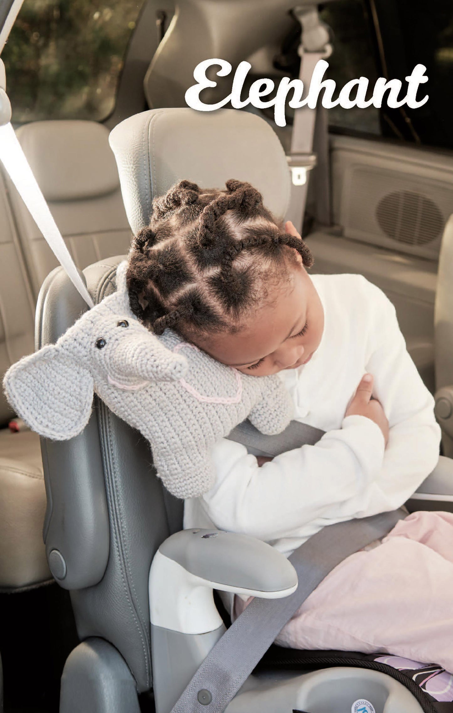 A young child naps in a car seat, resting their head on an adorable crocheted elephant pillow made with Car Seat Cuties patterns by Leisure Arts. The word "Elephant" appears in large white text at the top right of the image.