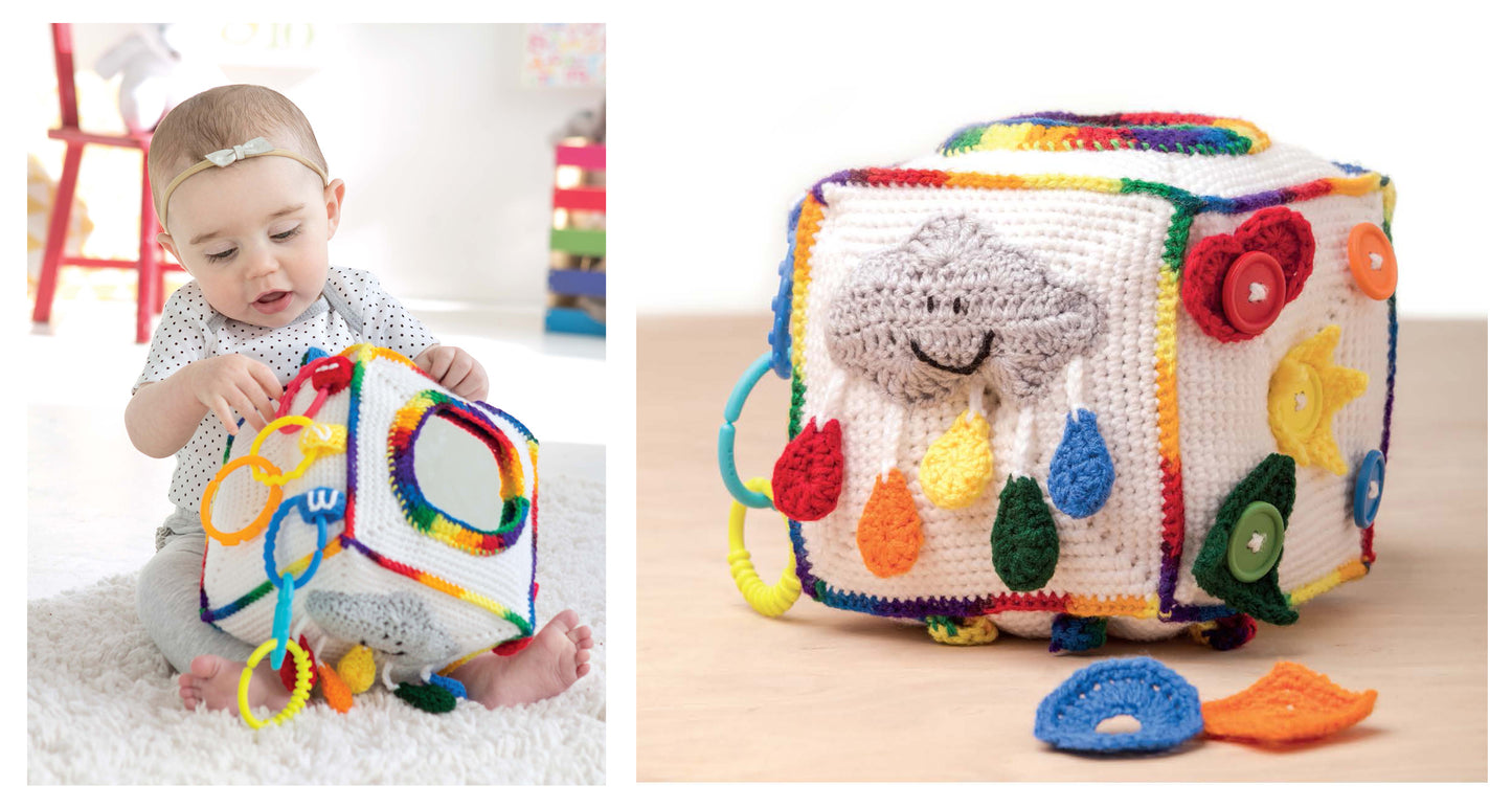 A baby enjoys interactive play with the colorful Everything Baby Crochet Digital Download by Leisure Arts, featuring textured shapes, a smiling cloud with rain, rings, buttons, and felt pieces made from easy crochet projects.