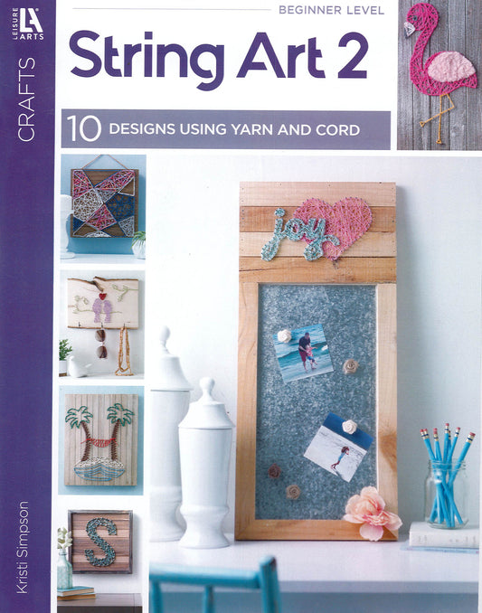The Leisure Arts String Art 2 book cover showcases beginner-friendly string art designs like a flamingo, geometric heart, "joy," ballerina, palm tree, and letter S on wood plaques—ideal inspiration for yarn and cord projects.