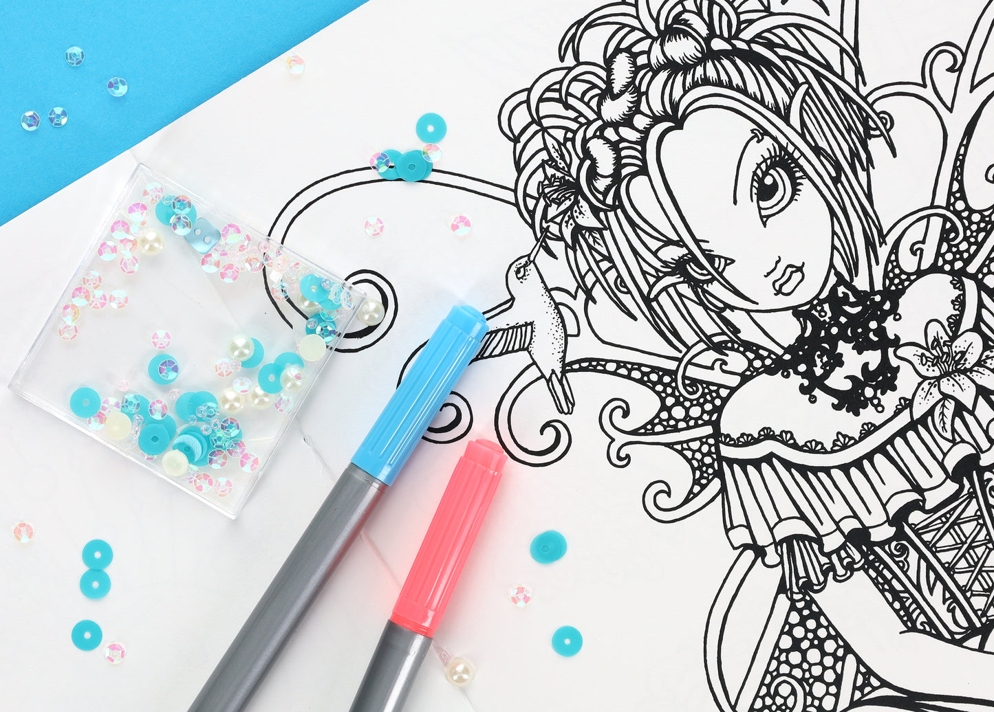 A page from Friends—32 Designs; Myka Jelina Coloring Collection by Leisure Arts displays a fairy-like girl with detailed hair and dress, alongside blue and pink markers and sequins on a blue and white background.