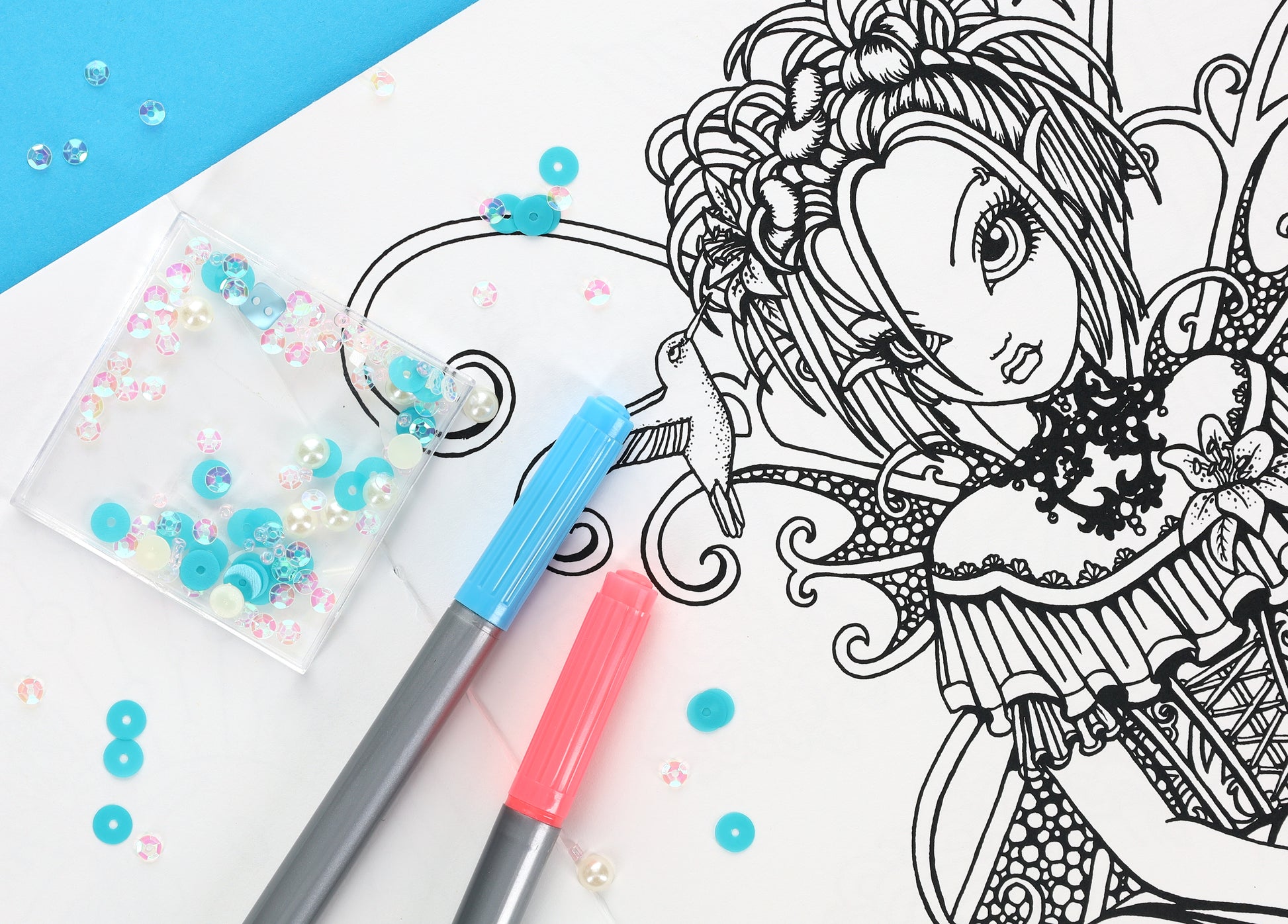 A page from Friends—32 Designs; Myka Jelina Coloring Collection by Leisure Arts displays a fairy-like girl with detailed hair and dress, alongside blue and pink markers and sequins on a blue and white background.