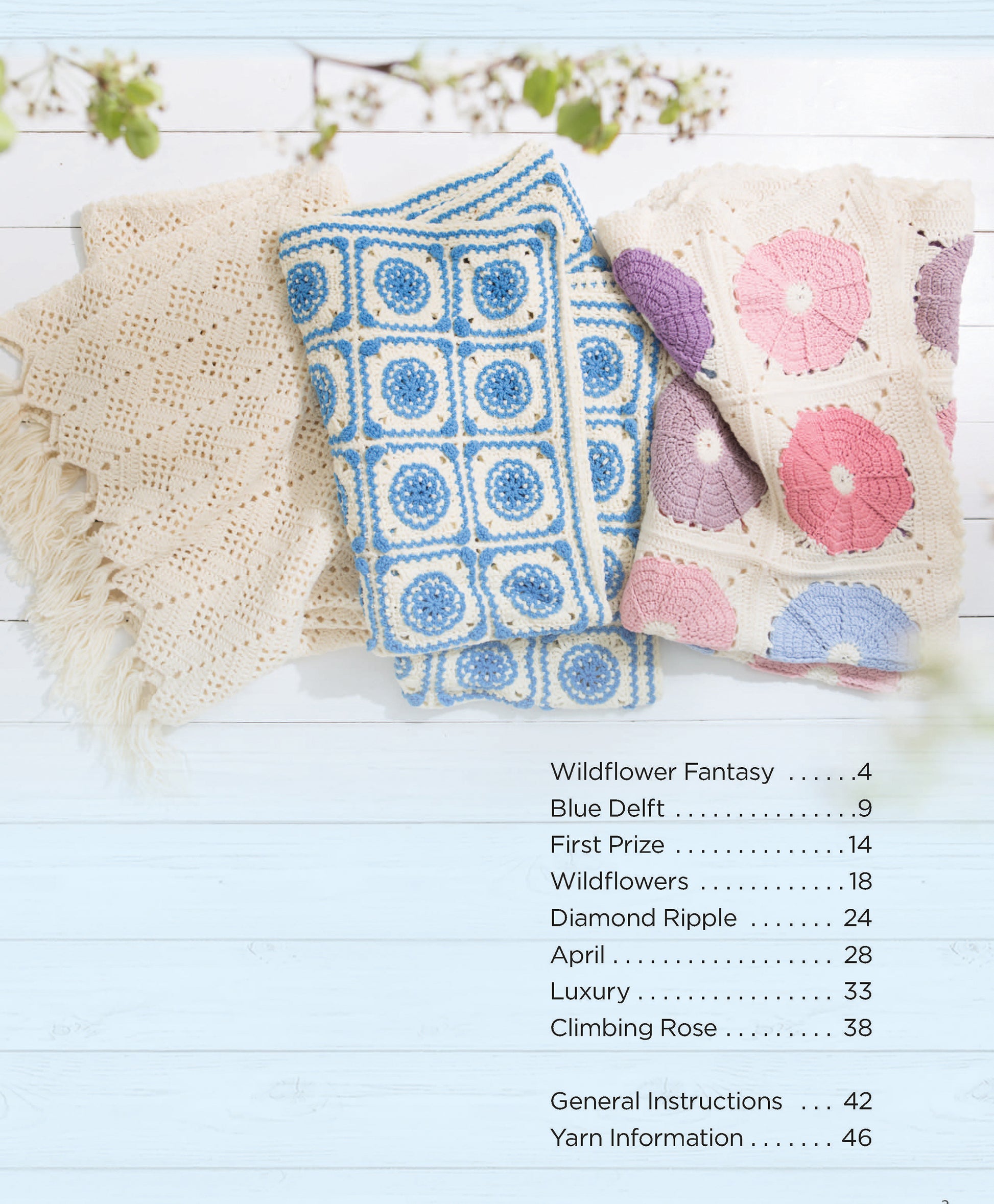 Three Crochet Spring Afghans by Leisure Arts—cream, blue and white, and pink with purple circles—are displayed on a light wooden surface for stylish home decor. A contents list is shown on the right.