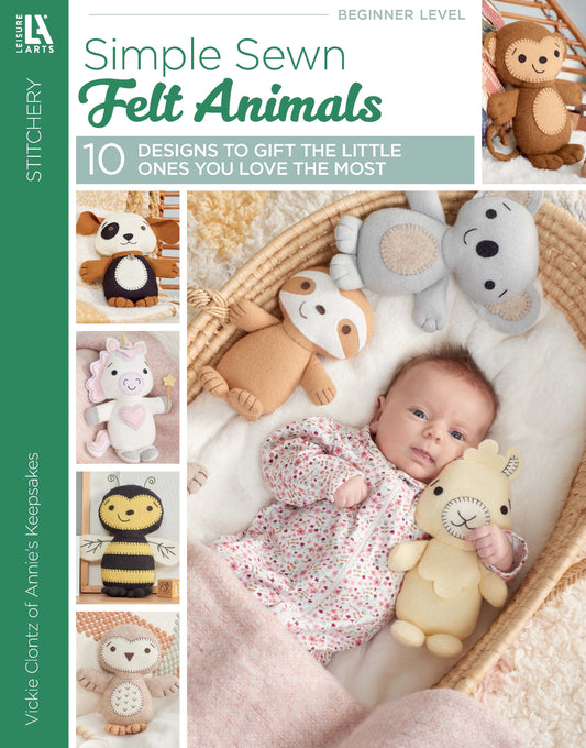 A baby in a pink outfit lies on a blanket surrounded by soft felt animal toys made from the "Simple Sewn Felt Animals" kit by Leisure Arts. The book's cover features photos of more adorable felt creations on the left side.