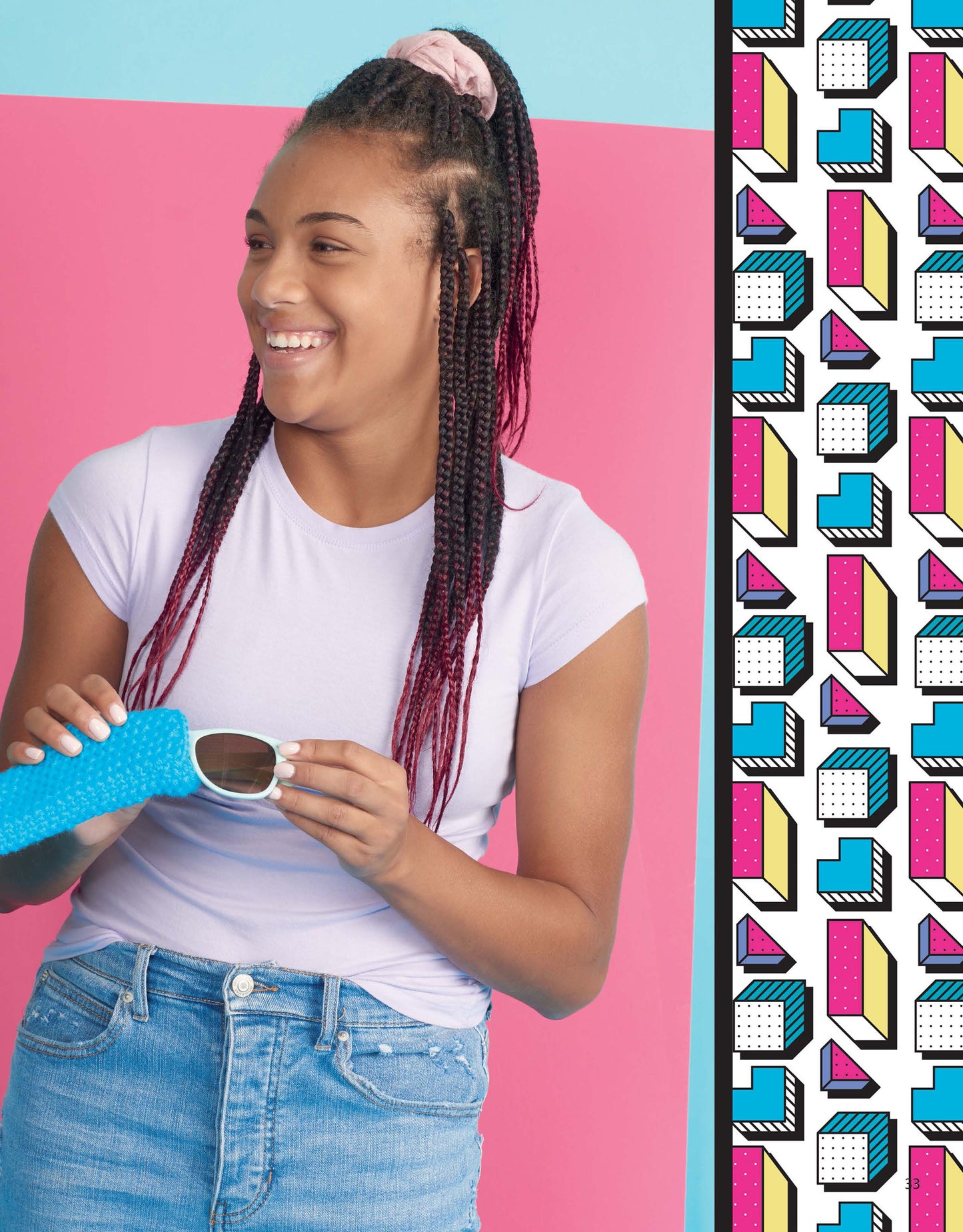 A smiling young woman with braided hair and a pink scrunchie poses with sunglasses beside a geometric panel, capturing the playful creativity of Leisure Arts’ Beginner Knitting with Shayna Anne Rose.