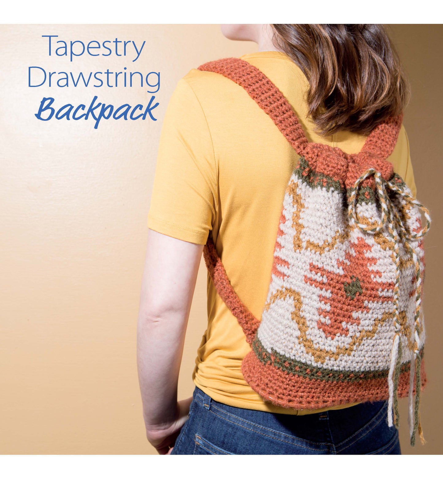 A person in a yellow shirt displays a crocheted drawstring backpack with orange, cream, and green tapestry design. The image features text: Tapestry Drawstring Backpack. Pattern from Crochet Handcrafted Handbags Book 3 by Leisure Arts.